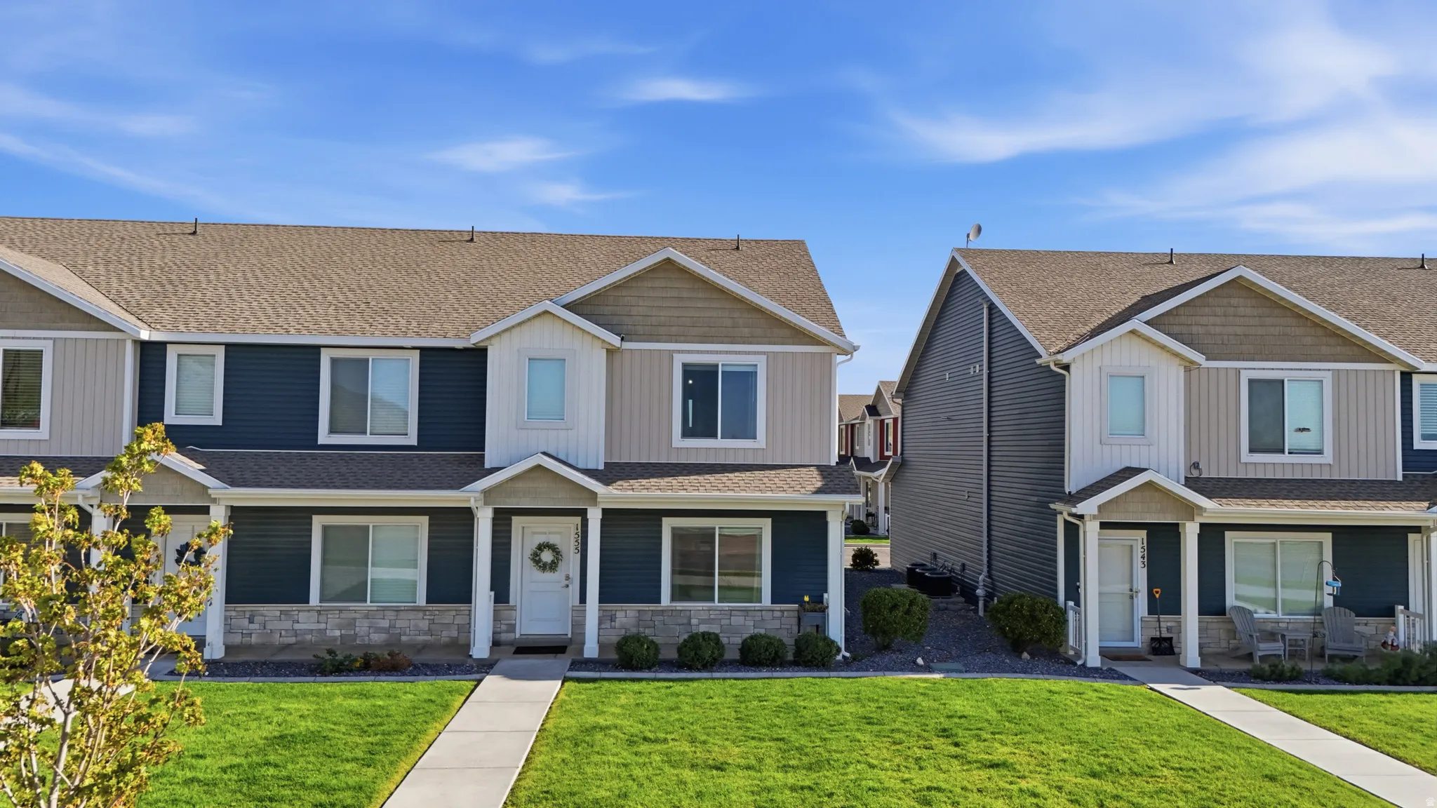 Craftsman house featuring a front lawn, stone siding, roof with shingles, and covered porch
