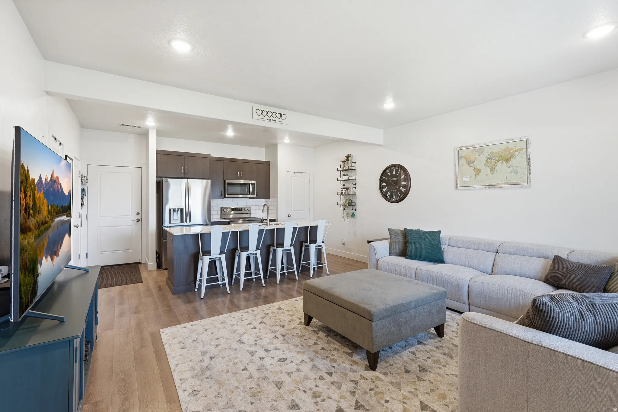 Living room with light wood finished floors and recessed lighting