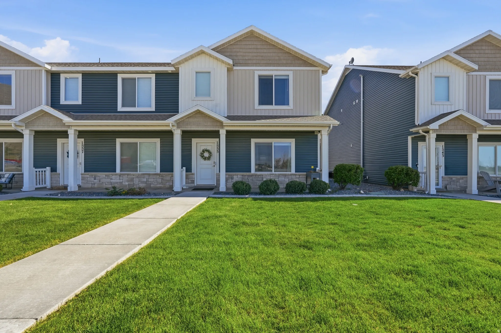 Craftsman-style home with stone siding, a front lawn, and a porch