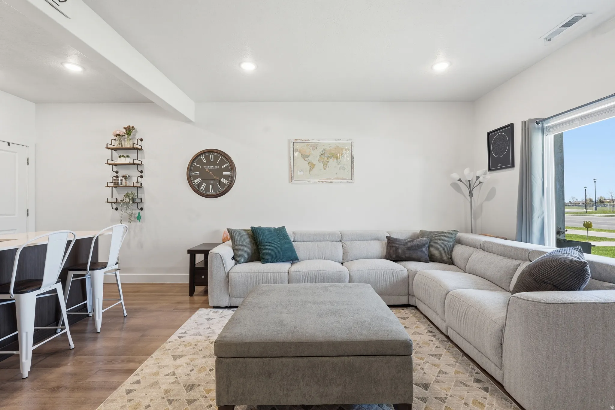 Living room with light wood-style flooring and recessed lighting