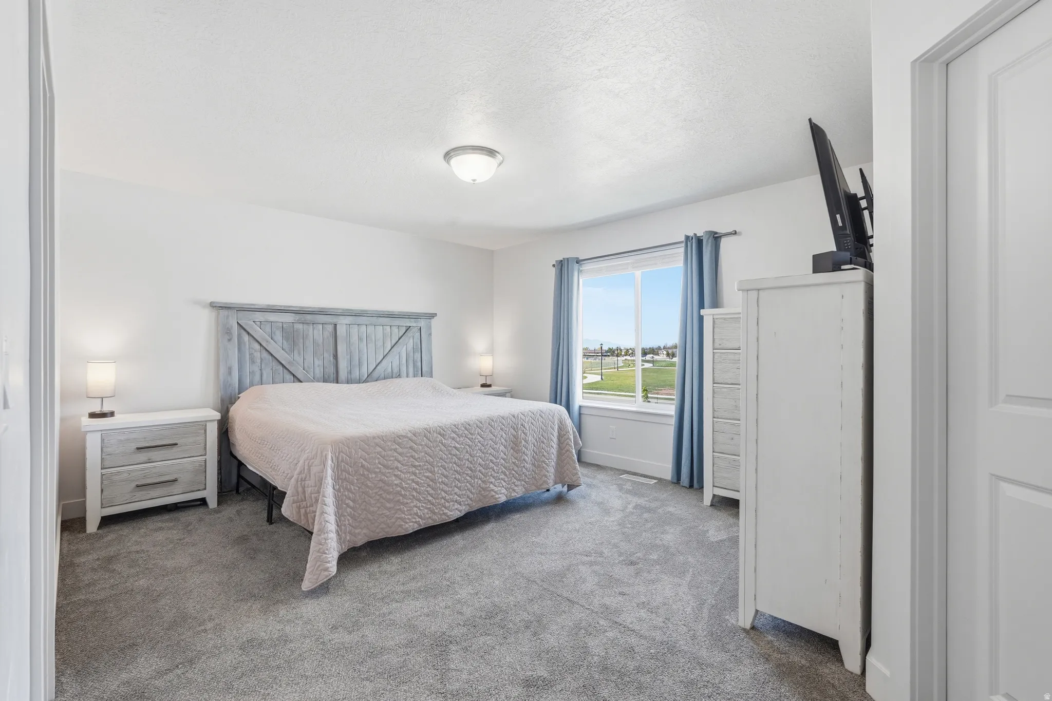 Bedroom featuring carpet floors and a textured ceiling