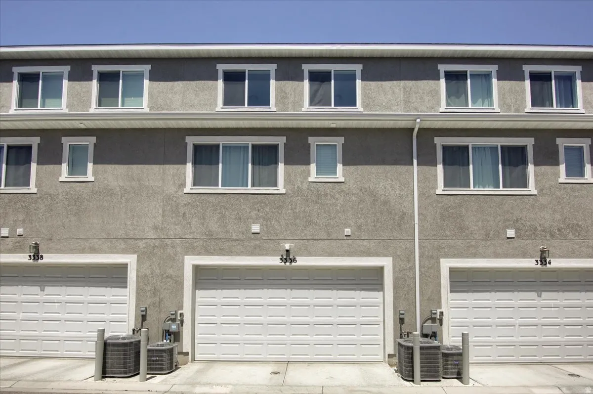 Rear view of house featuring an attached garage and stucco siding