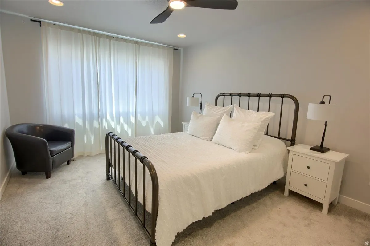 Bedroom featuring light carpet, ceiling fan, and recessed lighting