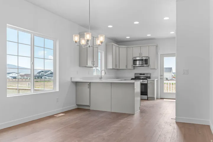 Open concept interior featuring wood-finish flooring and a contemporary chandelier