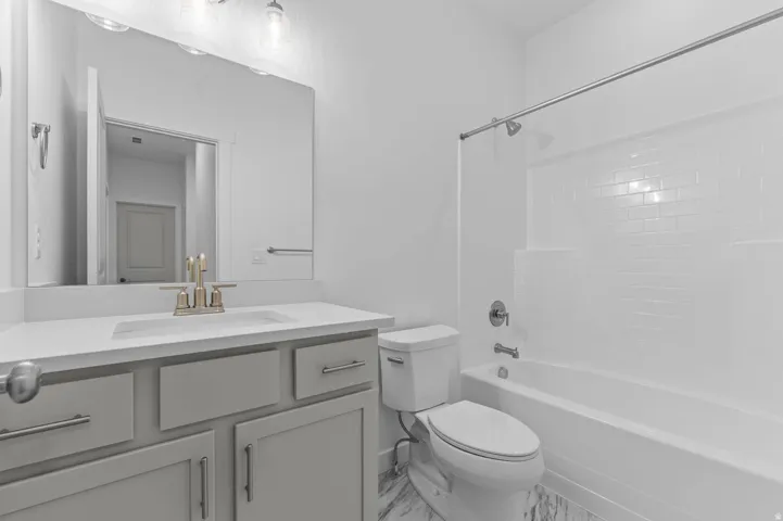 Bathroom featuring a light gray vanity with brushed nickel hardware, white countertop, and an undermount sink