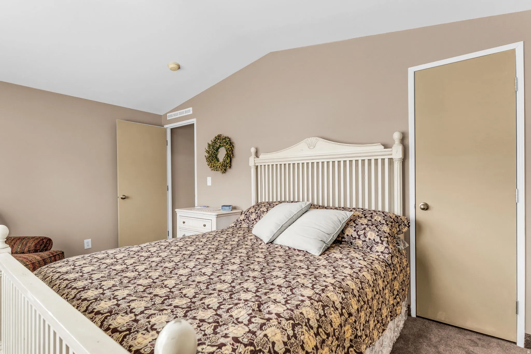 Bedroom featuring lofted ceiling and dark carpet