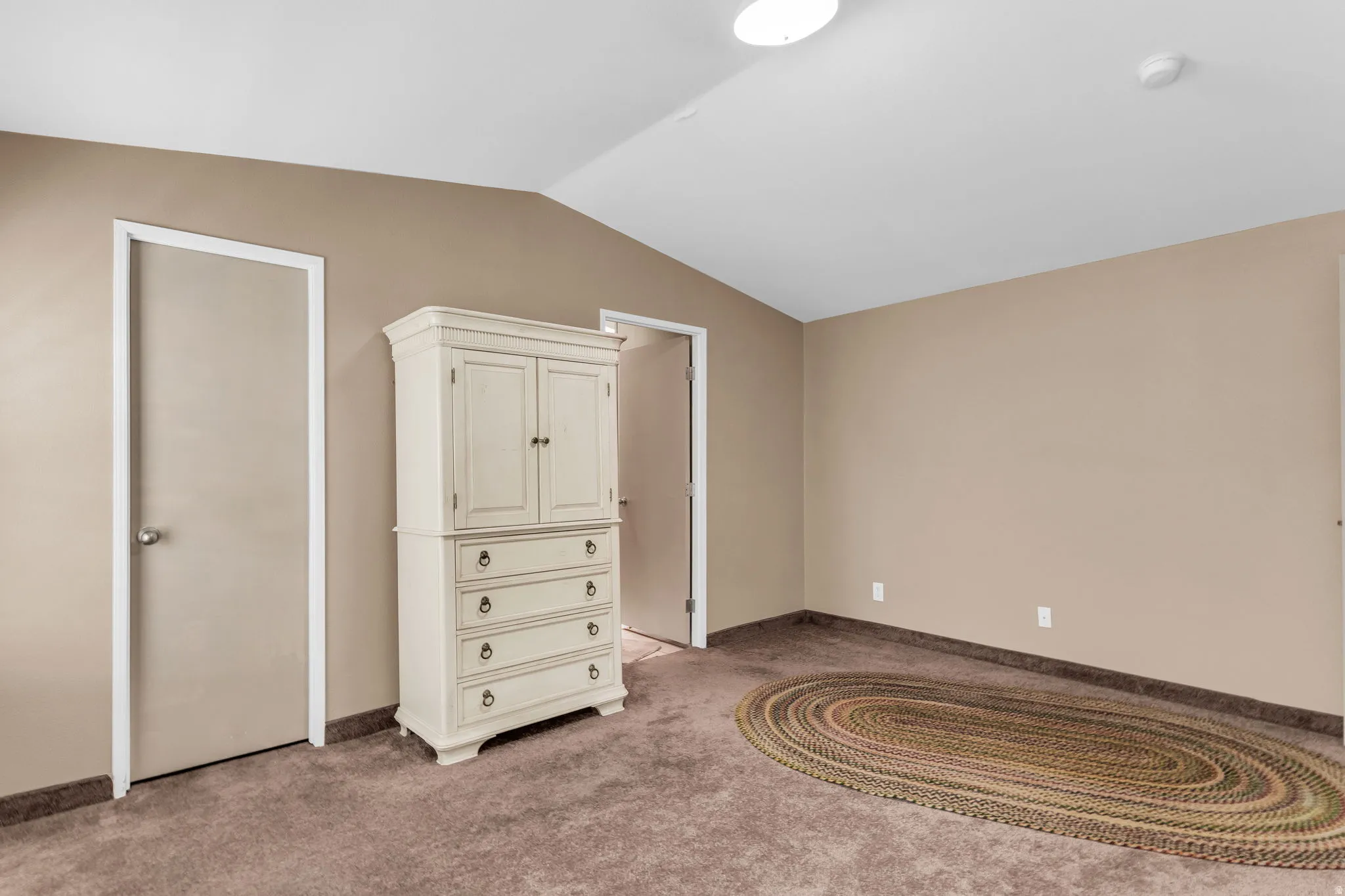 Unfurnished bedroom featuring light colored carpet