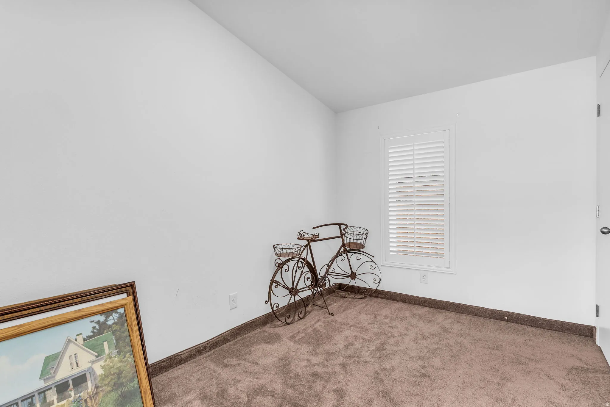 Unfurnished room featuring carpet flooring and vaulted ceiling