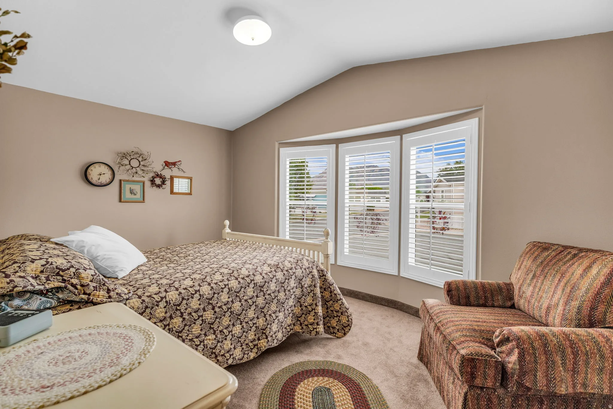 Bedroom featuring lofted ceiling and light colored carpet