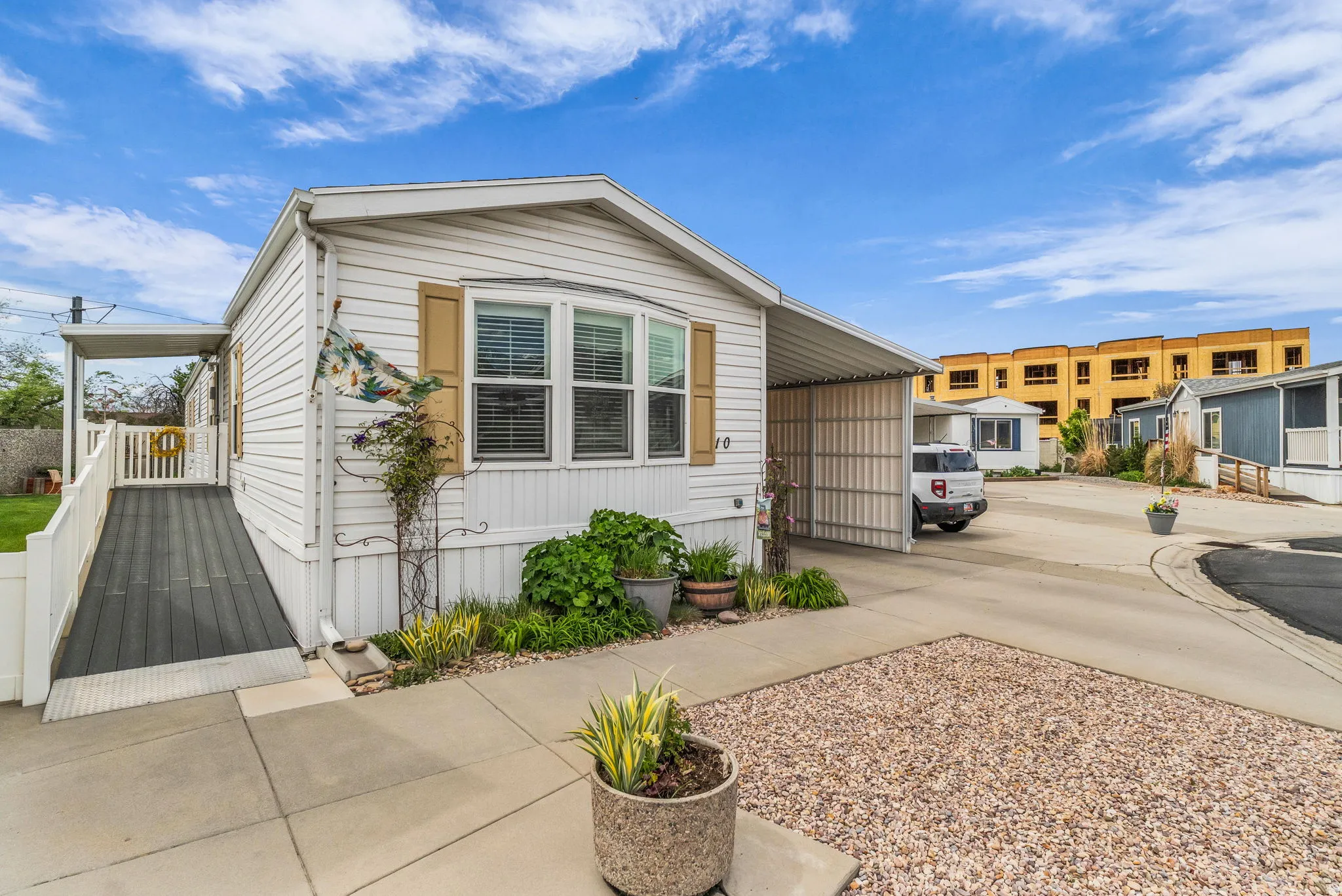 View of front facade with concrete driveway and a carport
