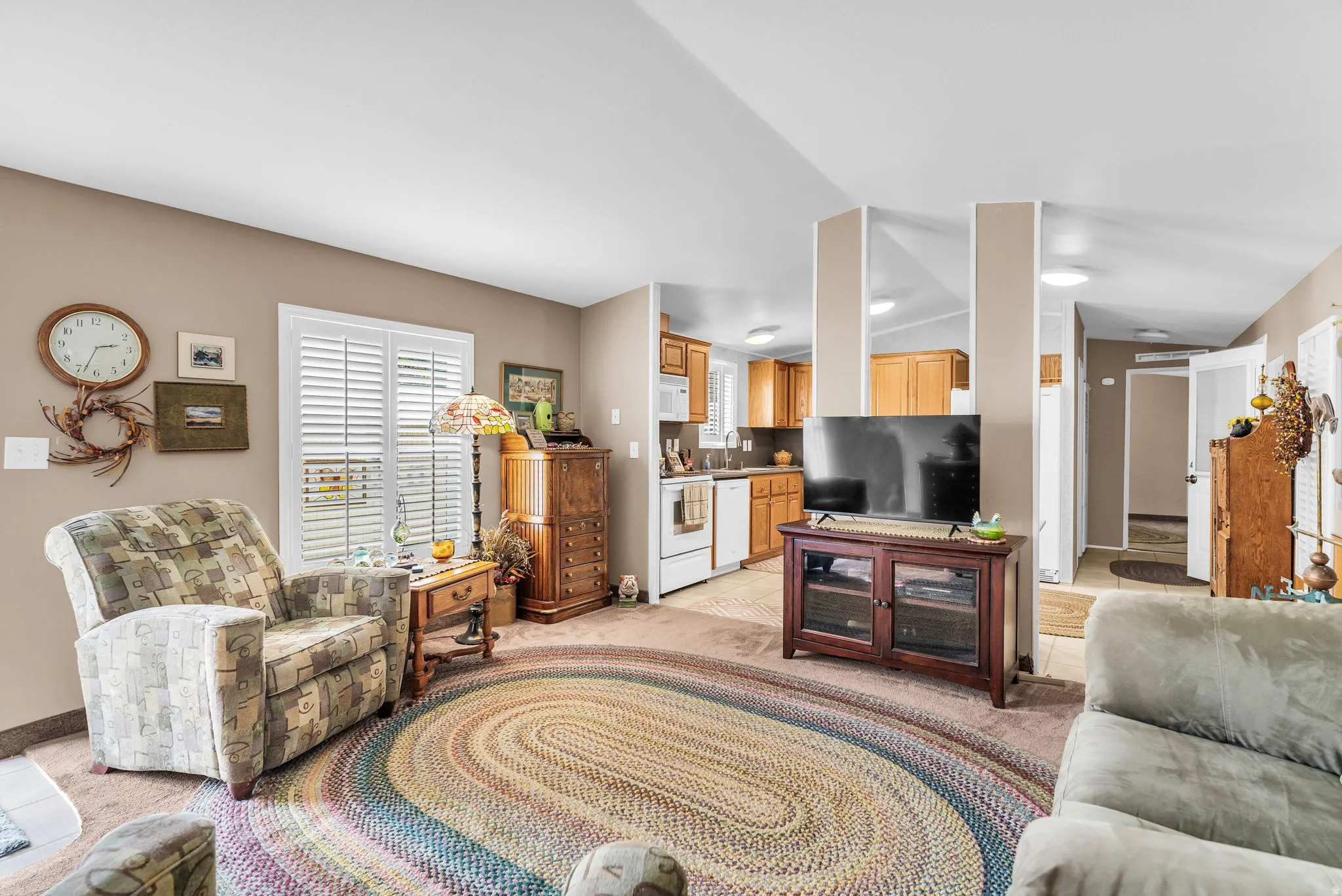 Living room with plenty of natural light, lofted ceiling, and light colored carpet