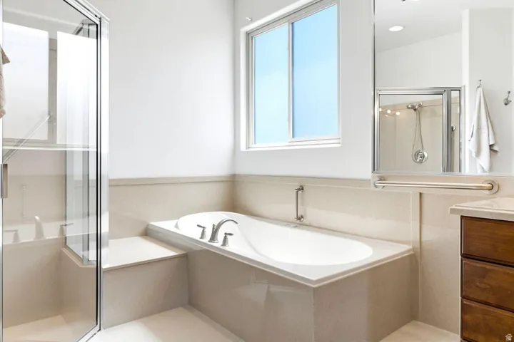 Bathroom featuring a shower stall, vanity, and a bath