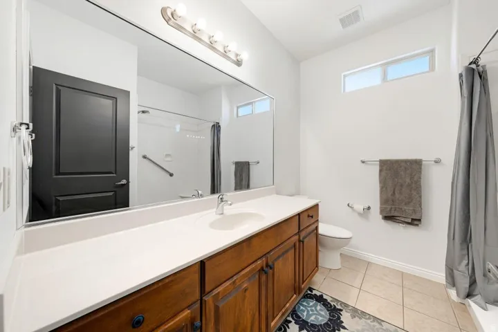 Full bathroom featuring vanity, a shower with shower curtain, and light tile patterned floors