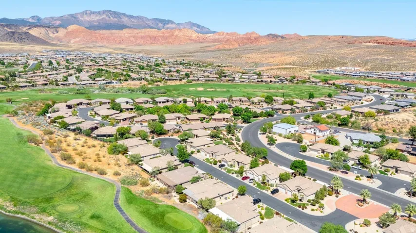 Aerial perspective of suburban area with a mountainous background and a golf club