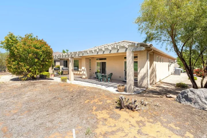 Rear view of house with stucco siding, a patio, and a pergola