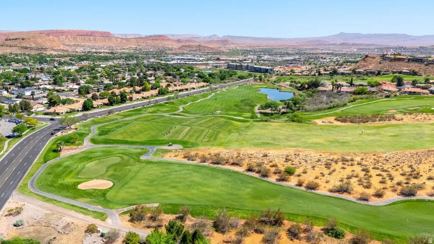 Aerial view of residential area featuring a golf course and a water and mountain view