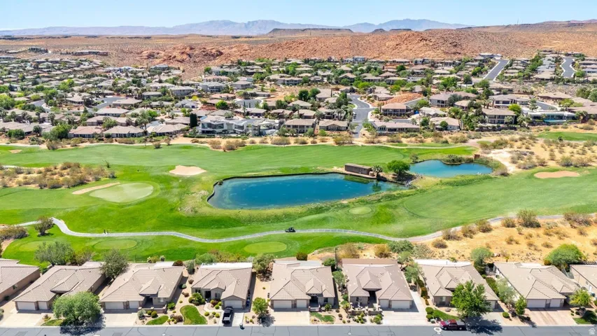 Aerial view of residential area featuring a water and mountain view and a golf club