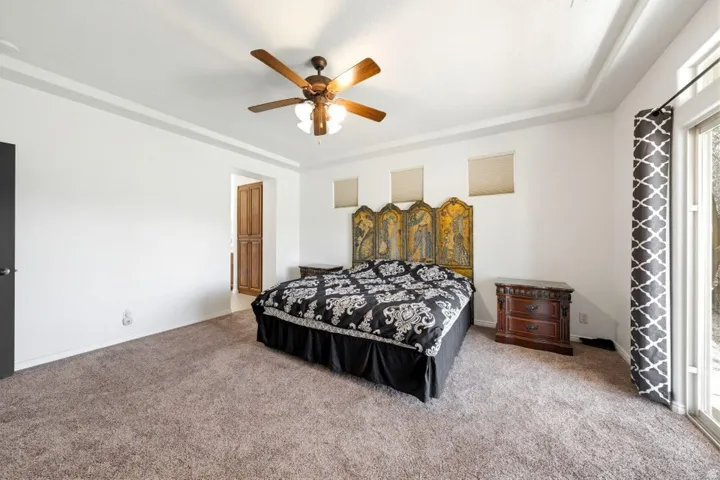Bedroom with carpet flooring, a ceiling fan, and access to outside