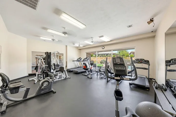 Gym featuring a ceiling fan and a textured ceiling