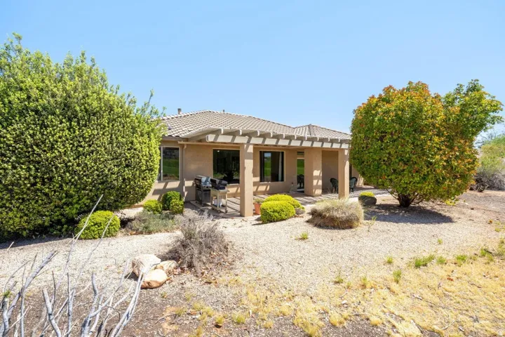 Rear view of property with stucco siding, a patio, and a tiled roof