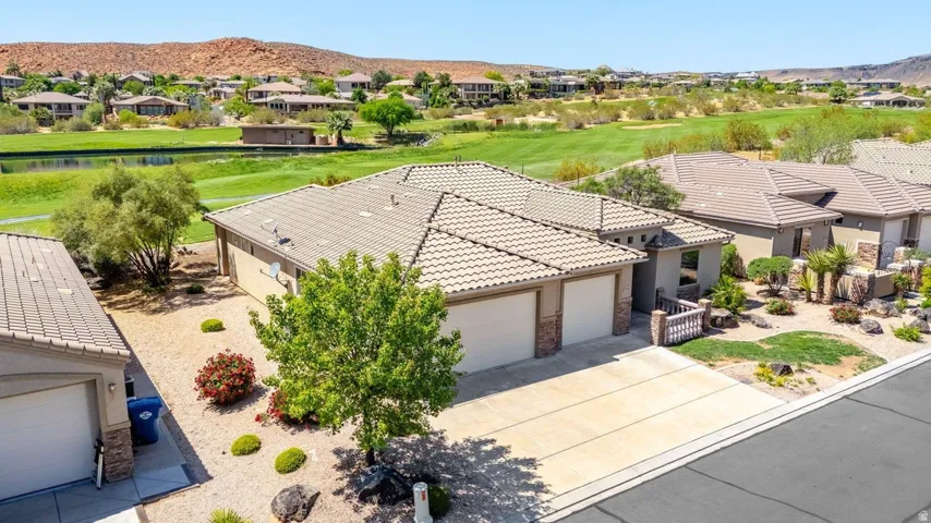 Aerial perspective of suburban area featuring a mountainous background and a golf course