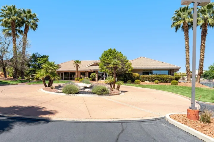 Ranch-style house featuring a tiled roof and curved driveway