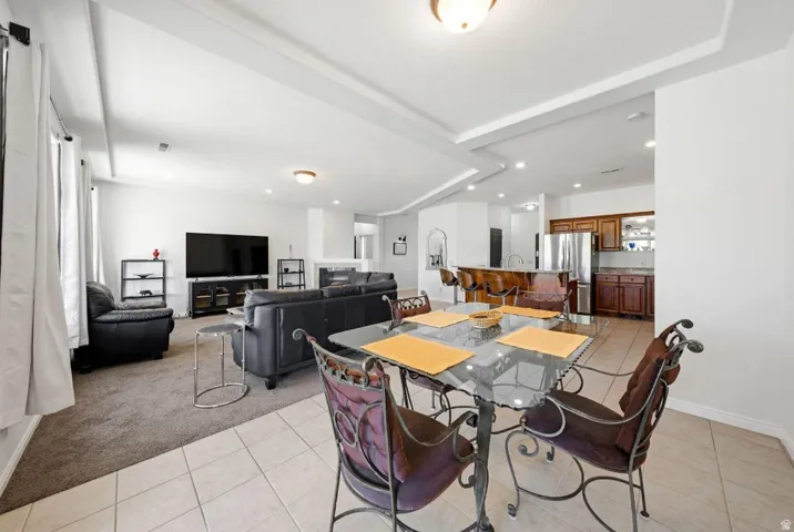 Dining room featuring light carpet, light tile patterned floors, and recessed lighting