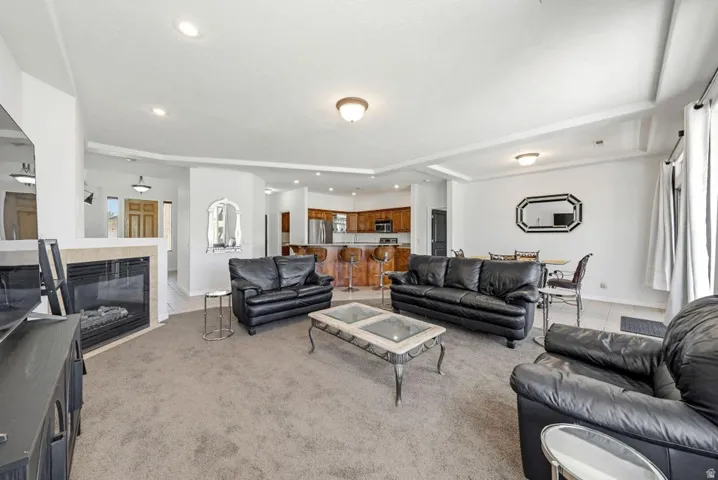 Living room featuring a fireplace, recessed lighting, tile patterned flooring, and carpet flooring