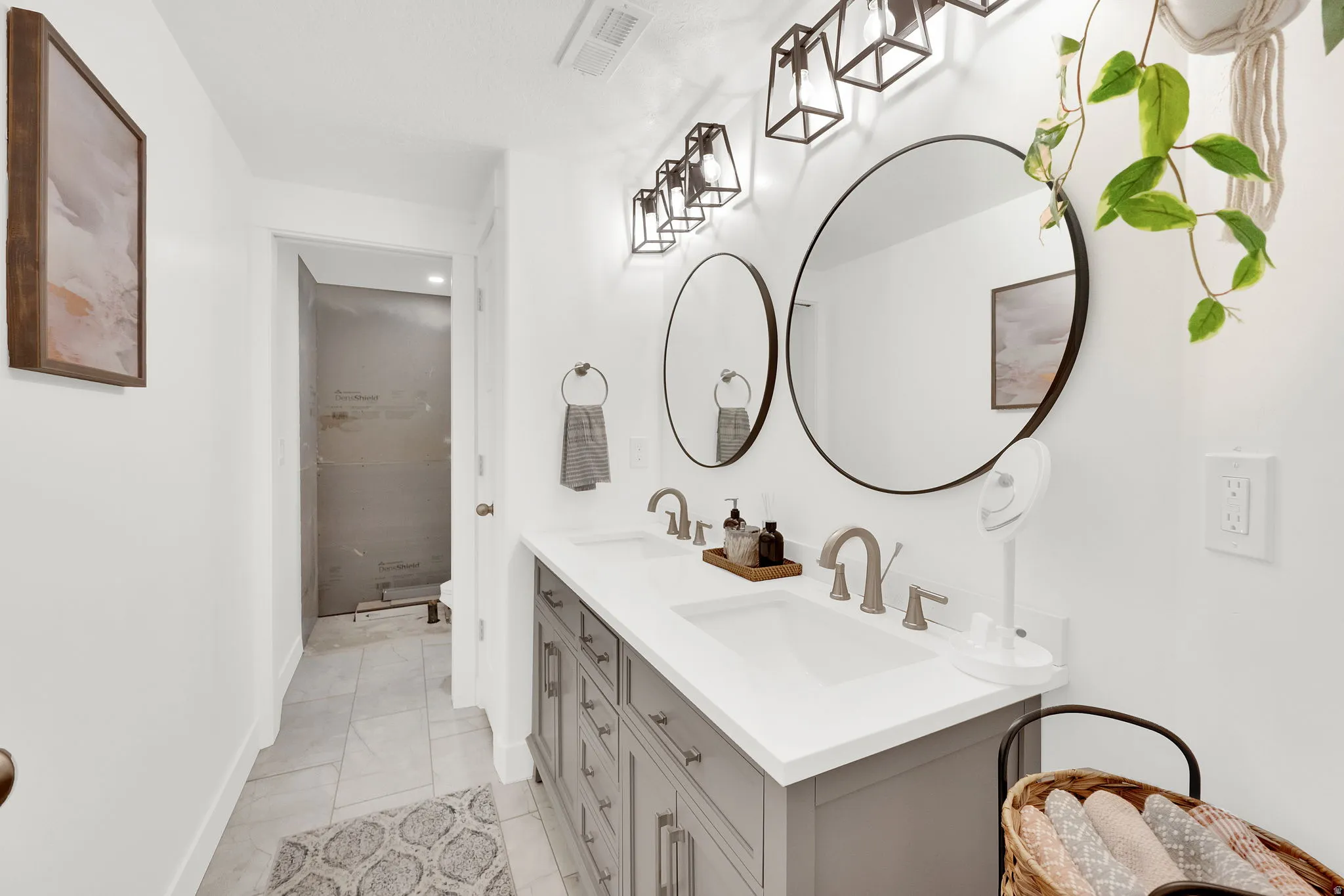 Full bath with double vanity and baseboards