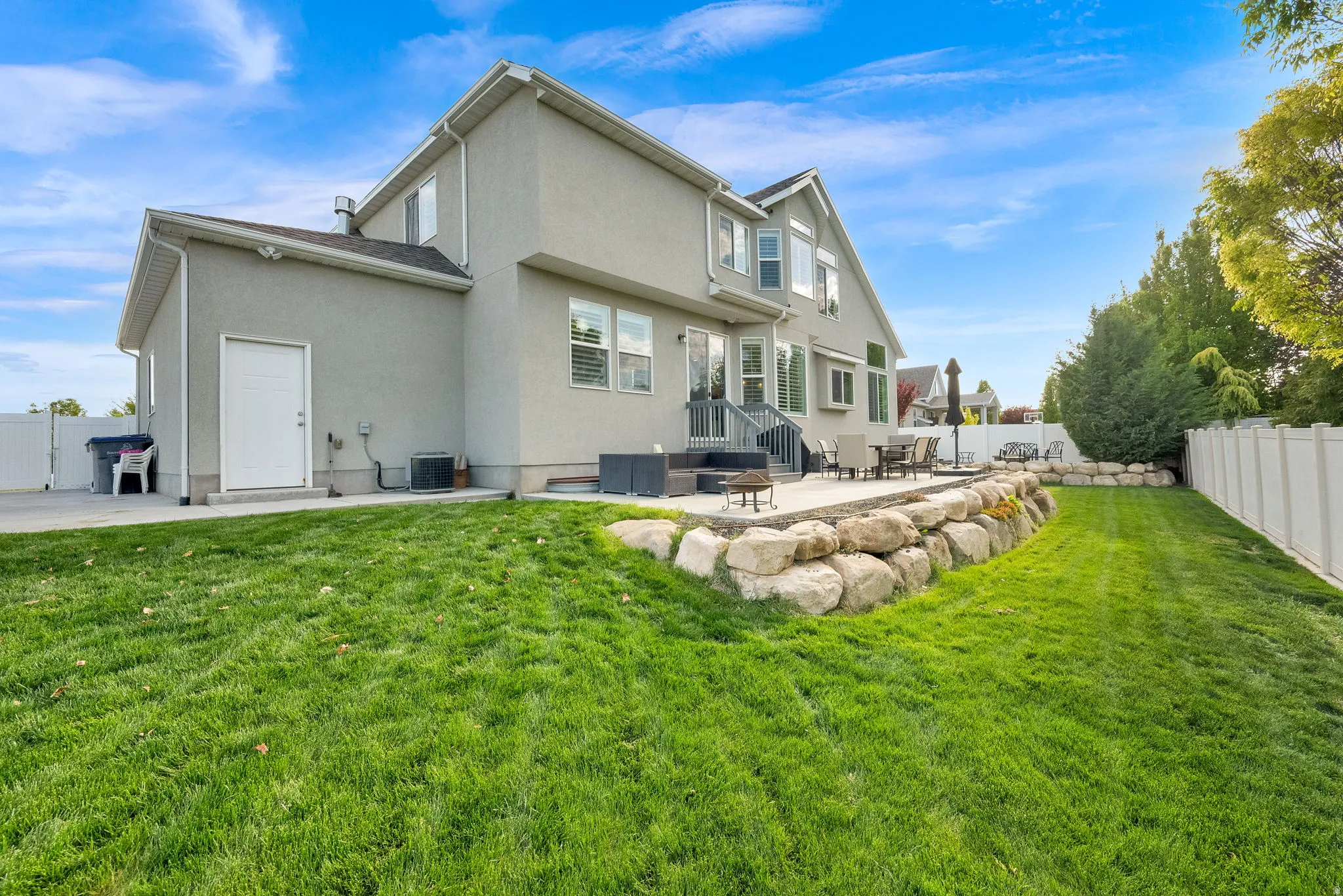 Back of house with a fenced backyard, a patio area, and stucco siding