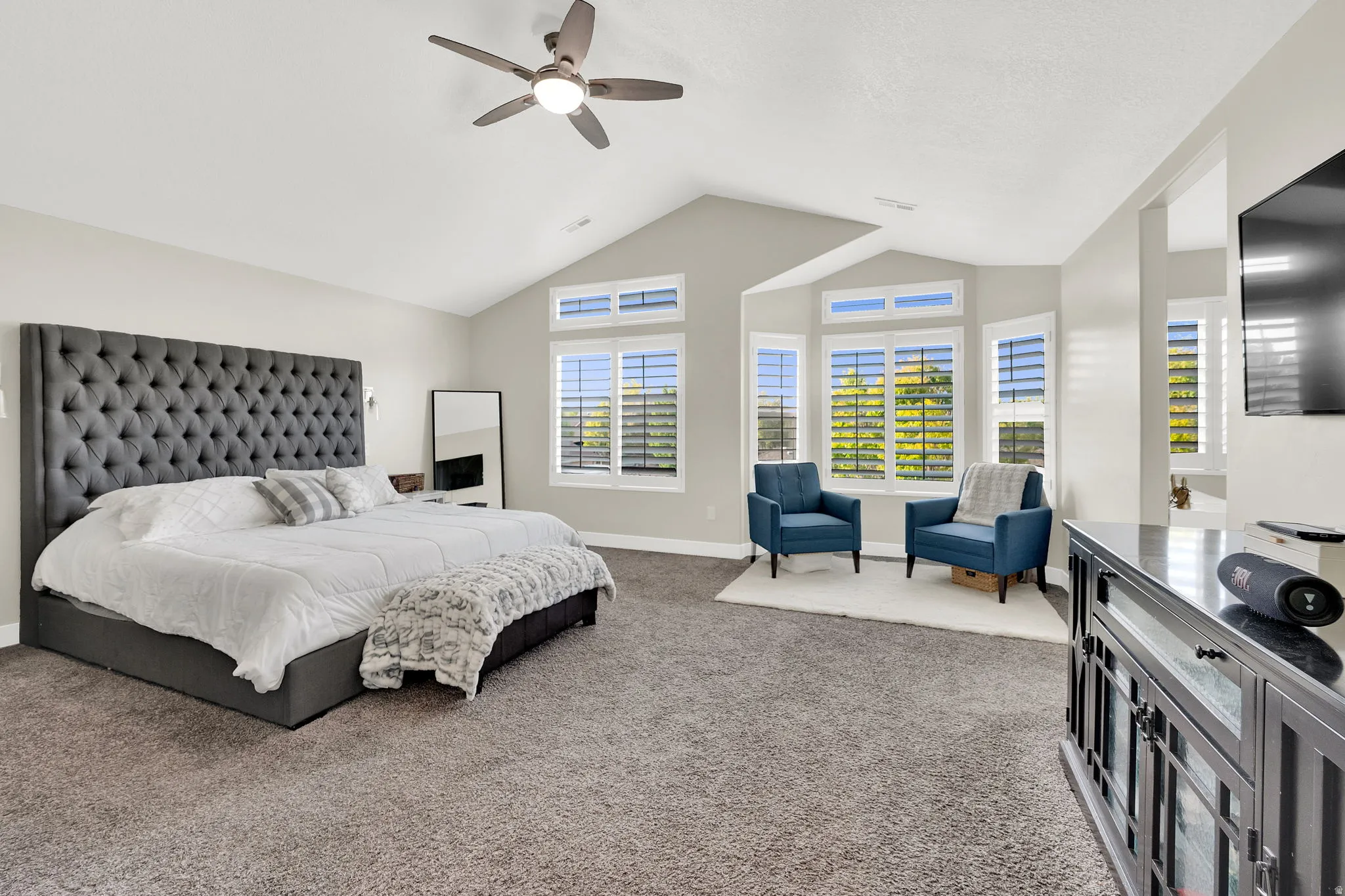 Bedroom with light colored carpet and a ceiling fan