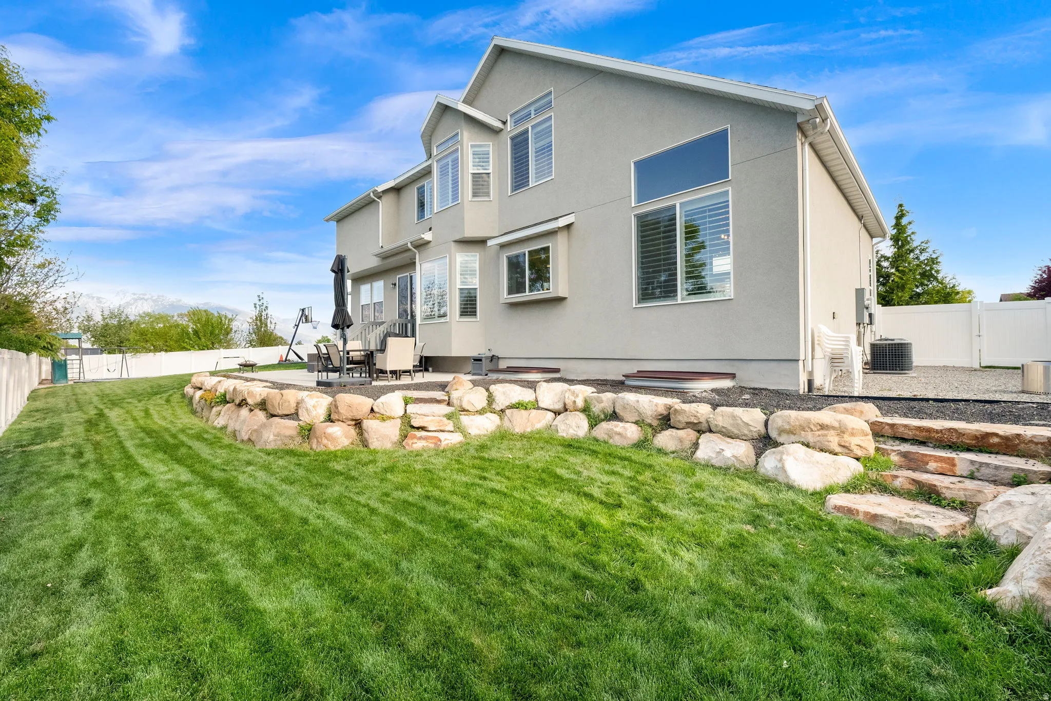 Back of house with a fenced backyard, a patio, stucco siding, and a gate