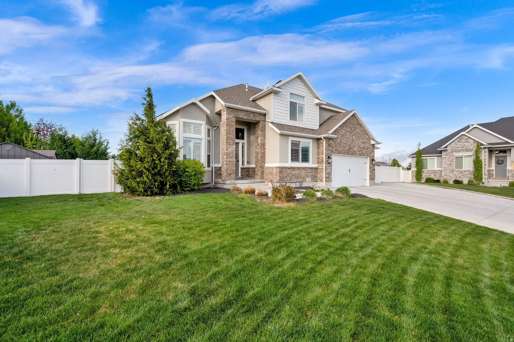 Craftsman house with driveway, a garage, a shingled roof, and stone siding