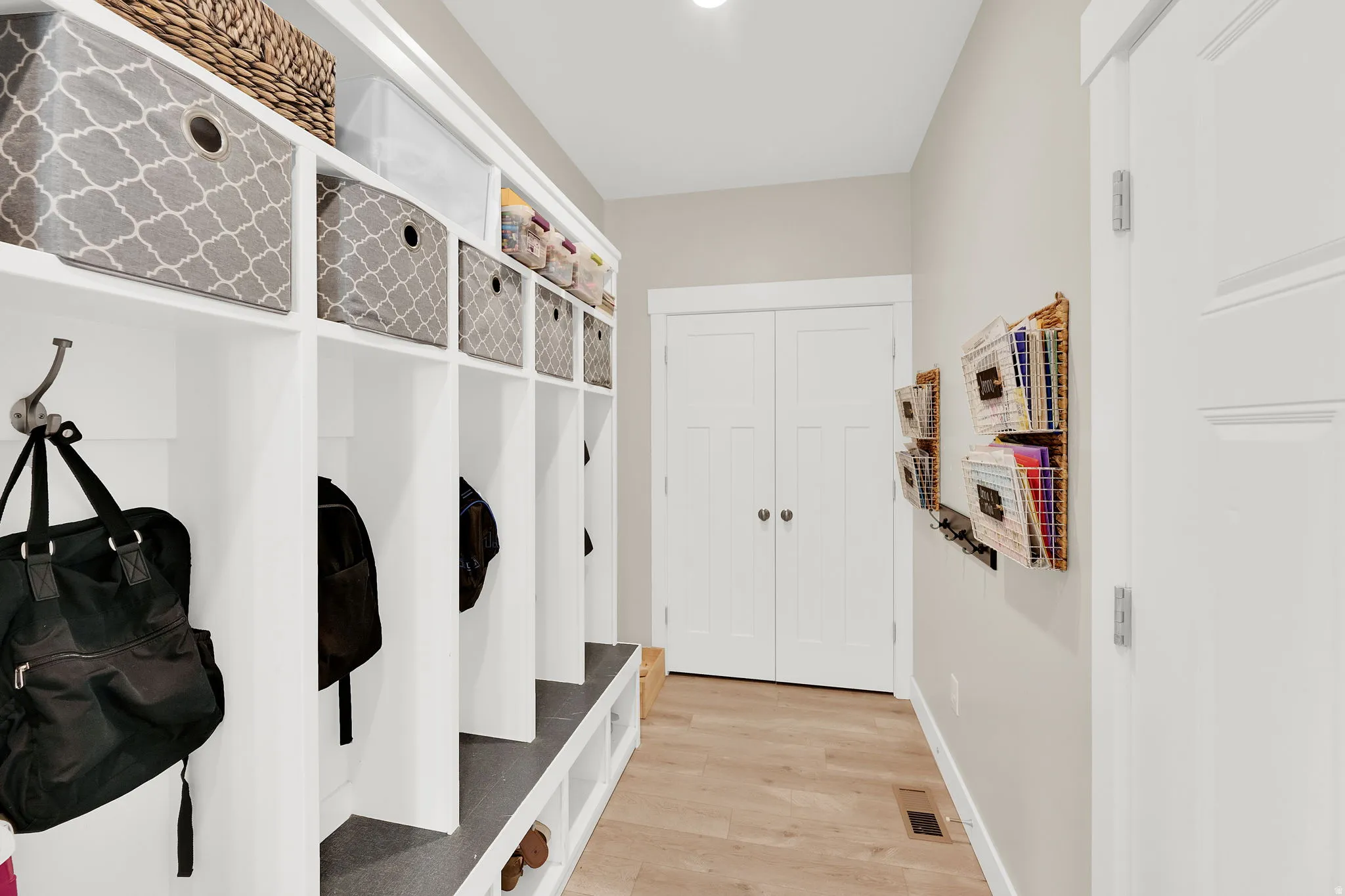 Mudroom featuring light wood-style floors and baseboards