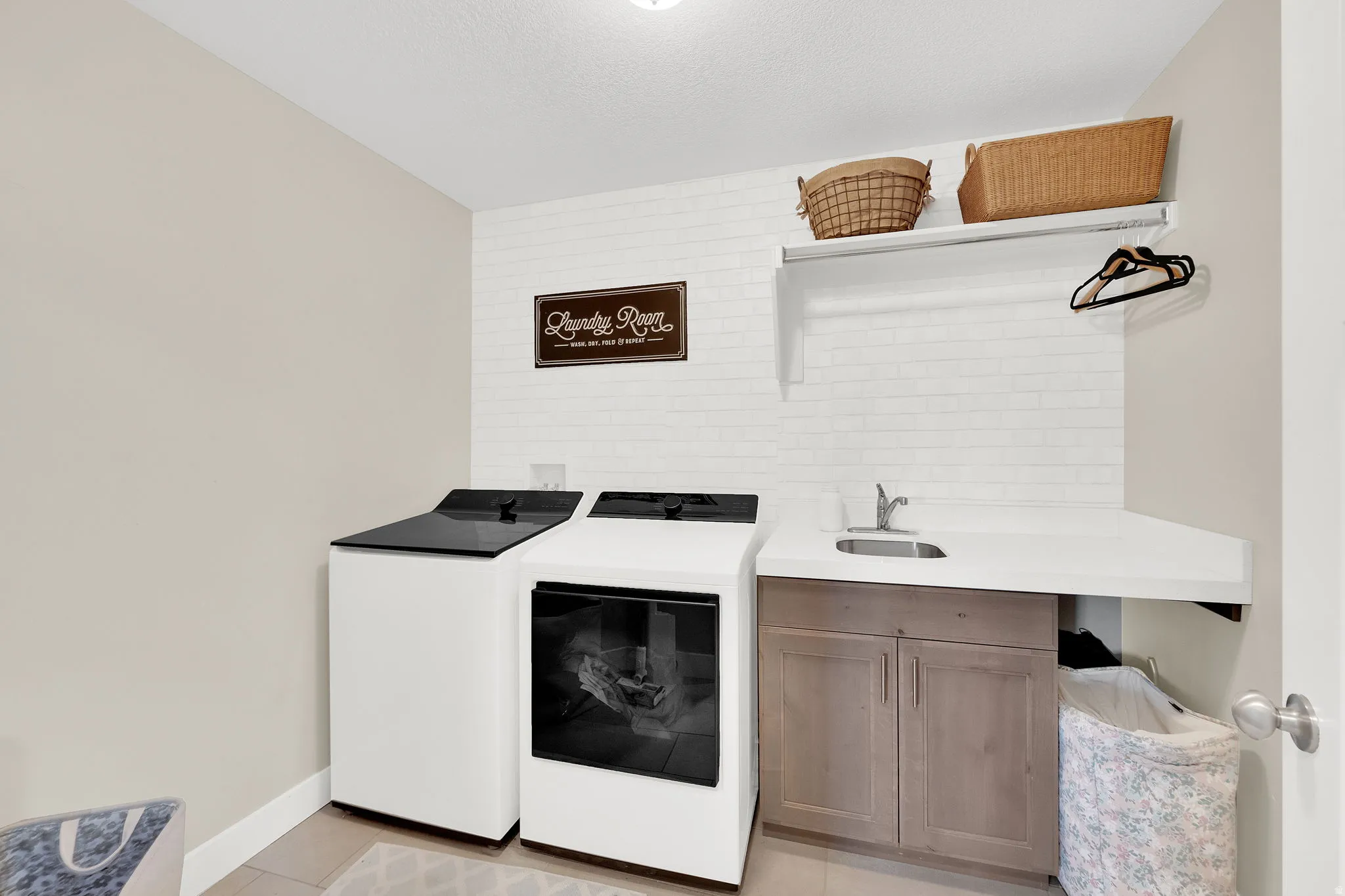 Laundry area featuring separate washer and dryer and cabinet space
