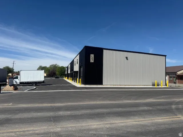 View of outdoor structure featuring uncovered parking