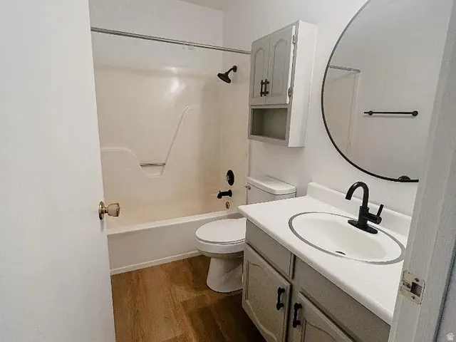 Bathroom with vanity, shower / washtub combination, and dark wood-style floors