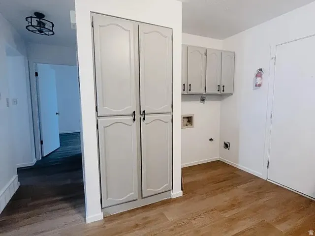 Laundry room featuring dark wood-style floors, cabinet space, and hookup for a washing machine