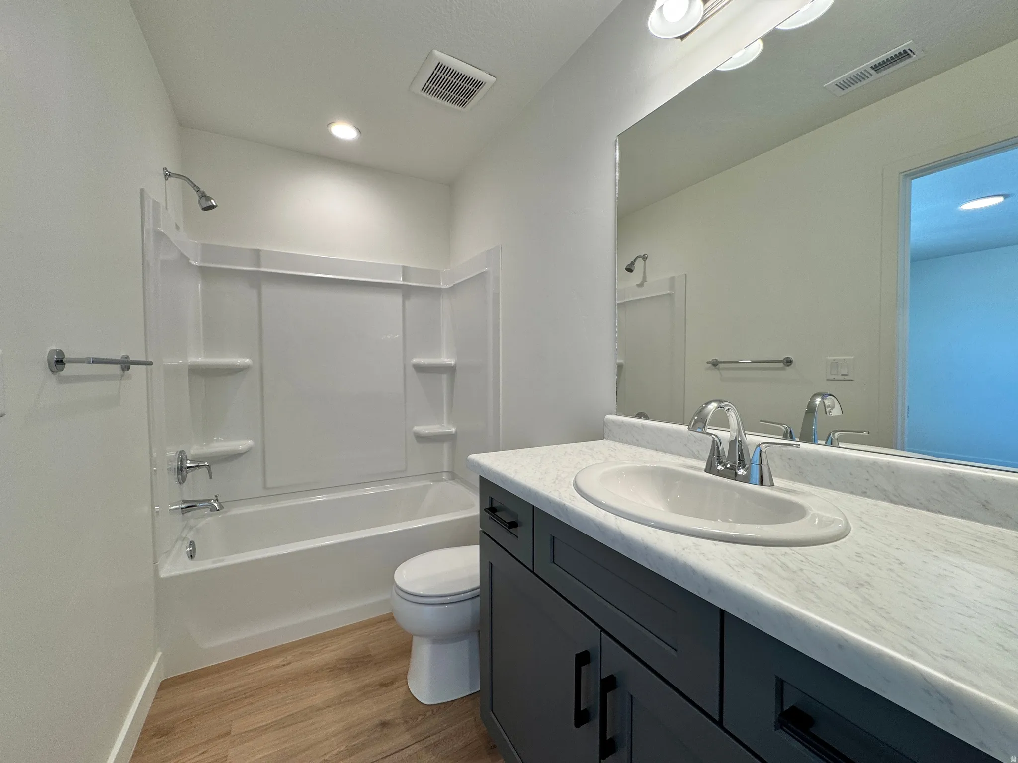 Bathroom featuring vanity, light wood-style floors, and shower / bathtub combination