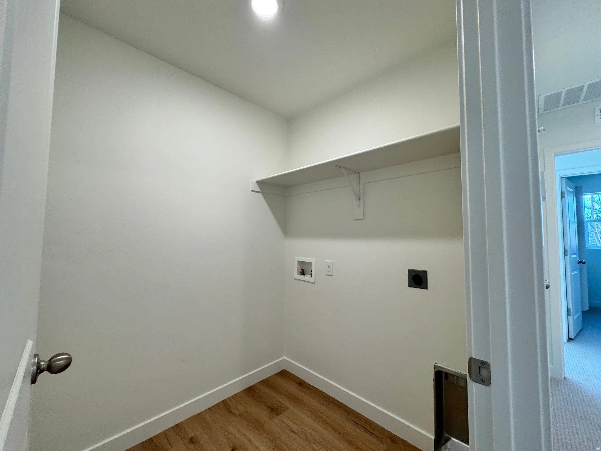 Laundry area featuring light wood-type flooring, hookup for an electric dryer, and hookup for a washing machine