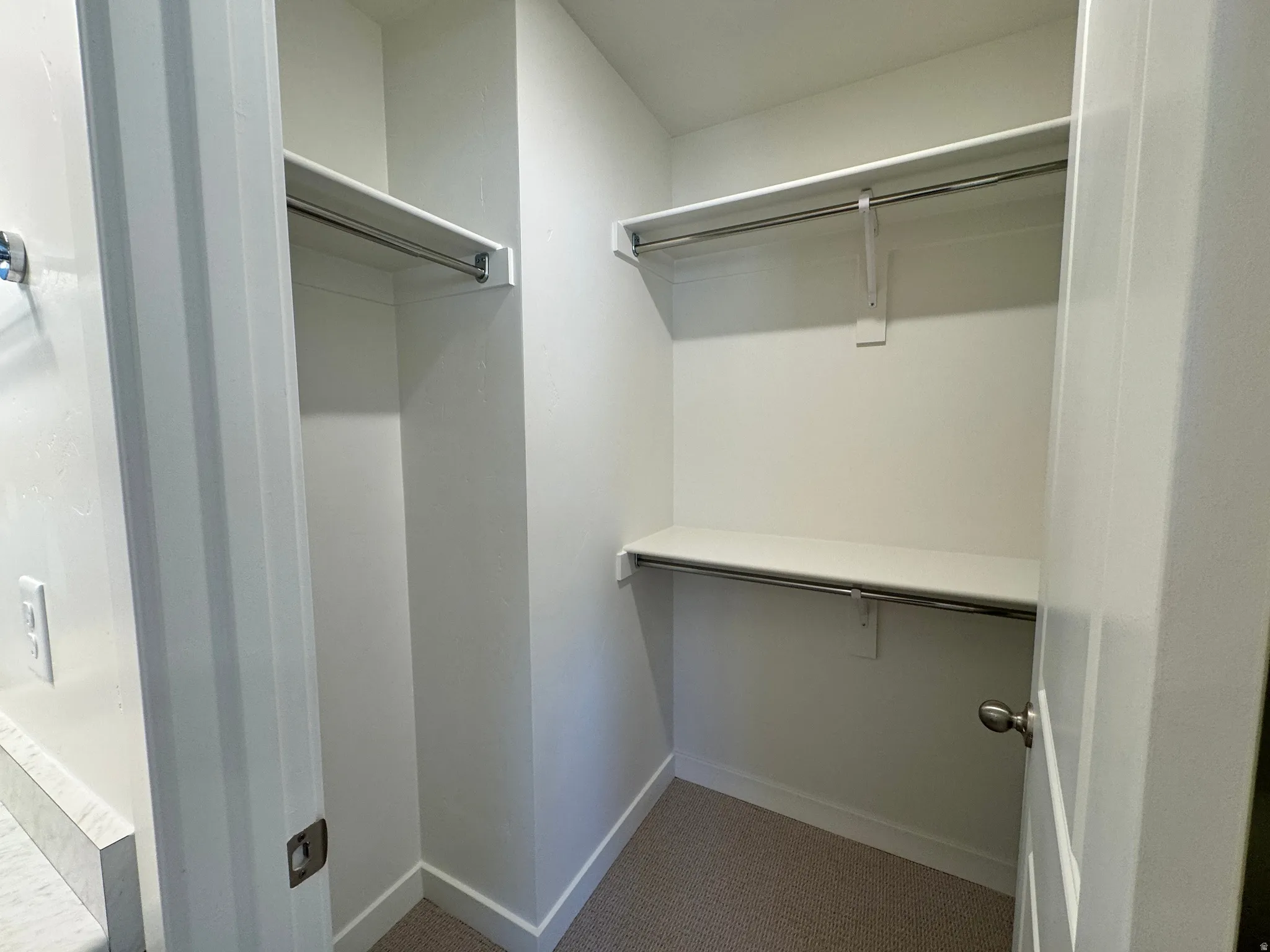 Walk in closet featuring dark colored carpet