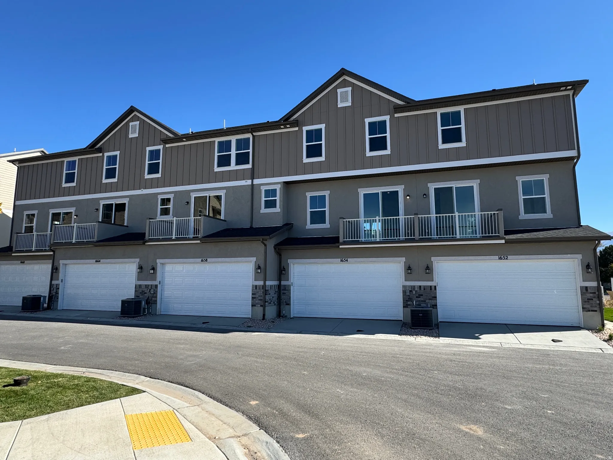 View of front of house featuring stone siding, a garage, and stucco siding
