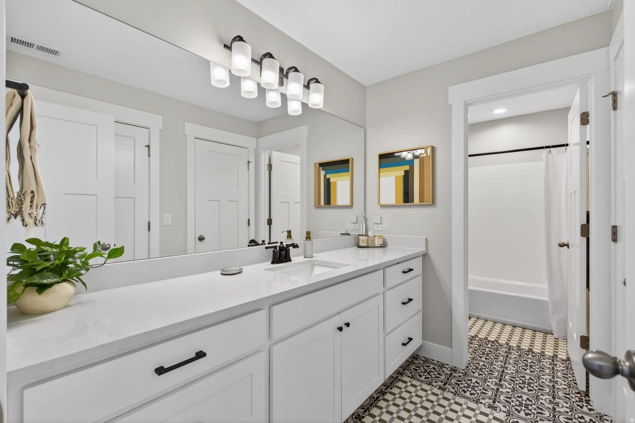 Full bath with vanity, shower / bathtub combination with curtain, and light tile patterned flooring