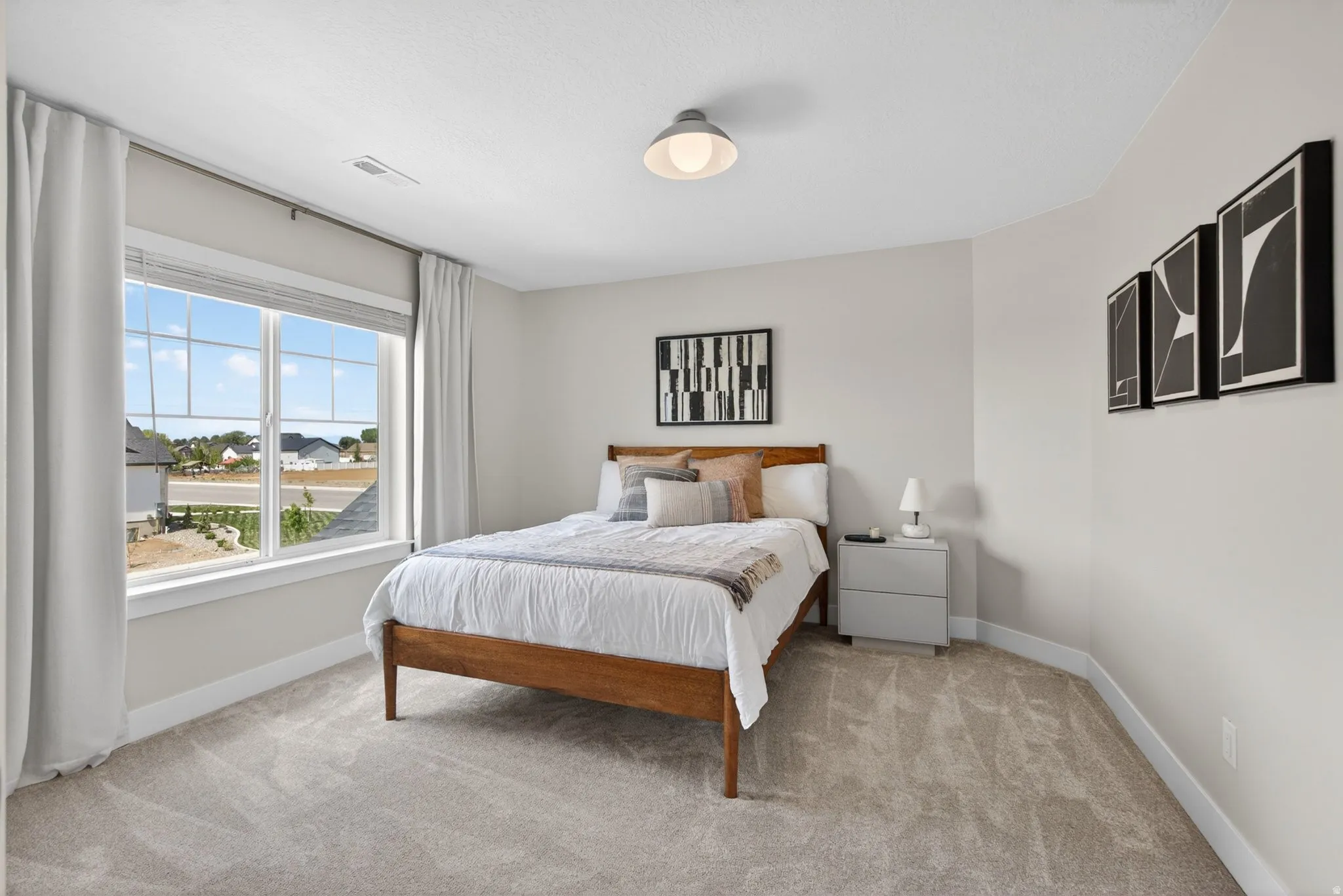 Bedroom featuring light colored carpet and baseboards
