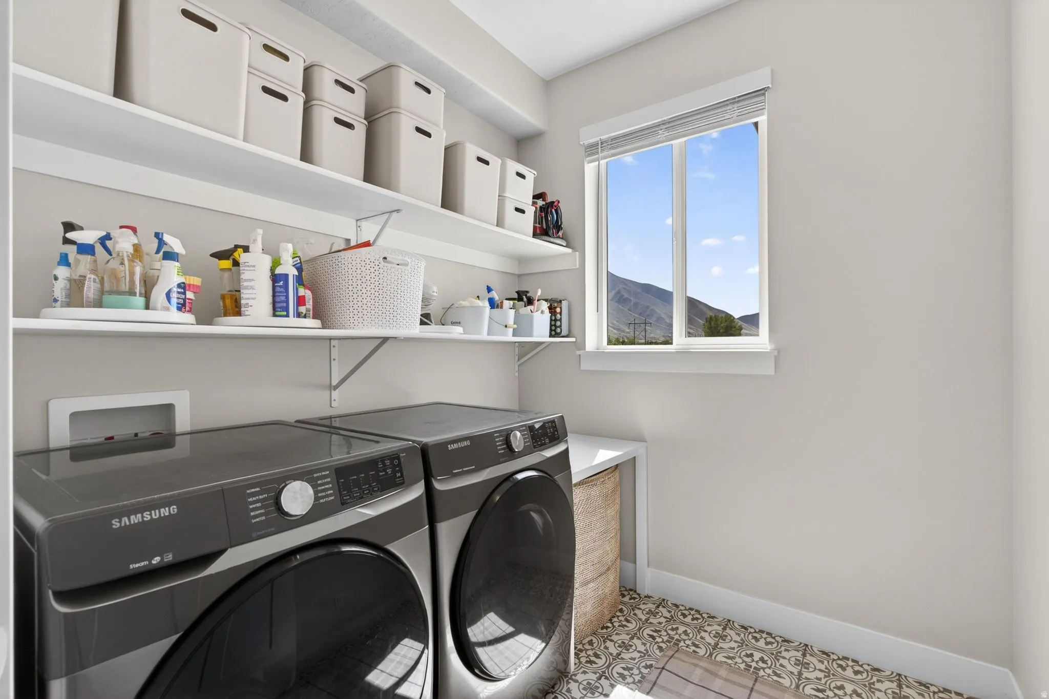 Laundry area with light tile patterned floors and washing machine and dryer