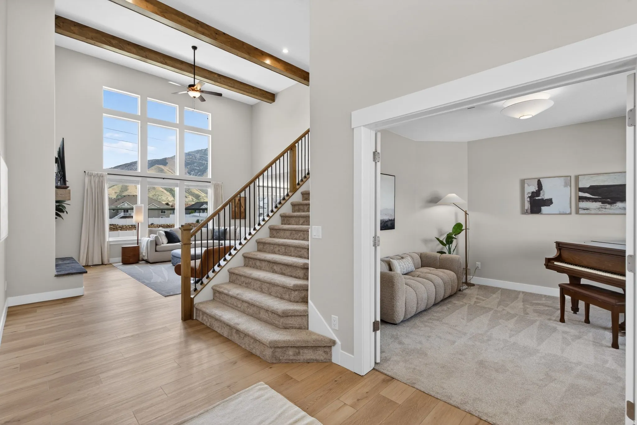 Stairs featuring hardwood / wood-style flooring, a mountain view, and a ceiling fan