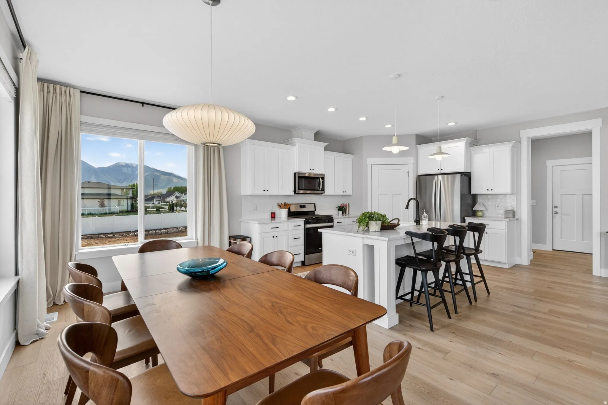 Dining space with a mountain view, light wood-style floors, and recessed lighting