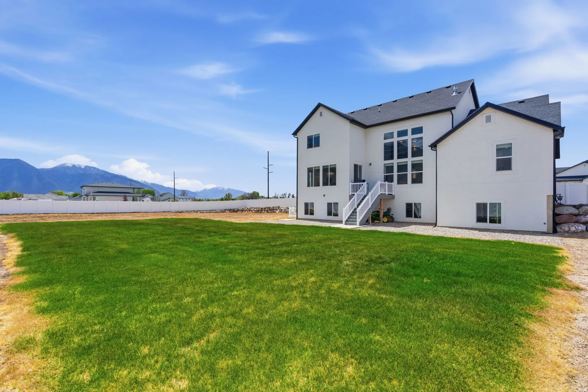 Rear view of property with a mountain view, a patio area, and stucco siding