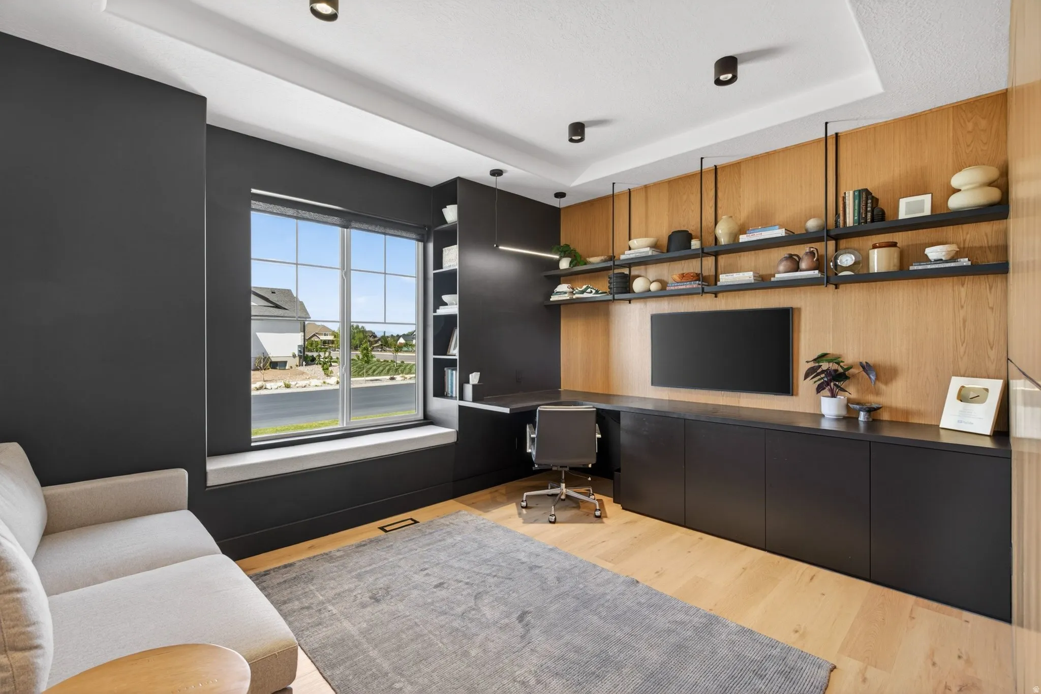 Office featuring built in desk and a tray ceiling