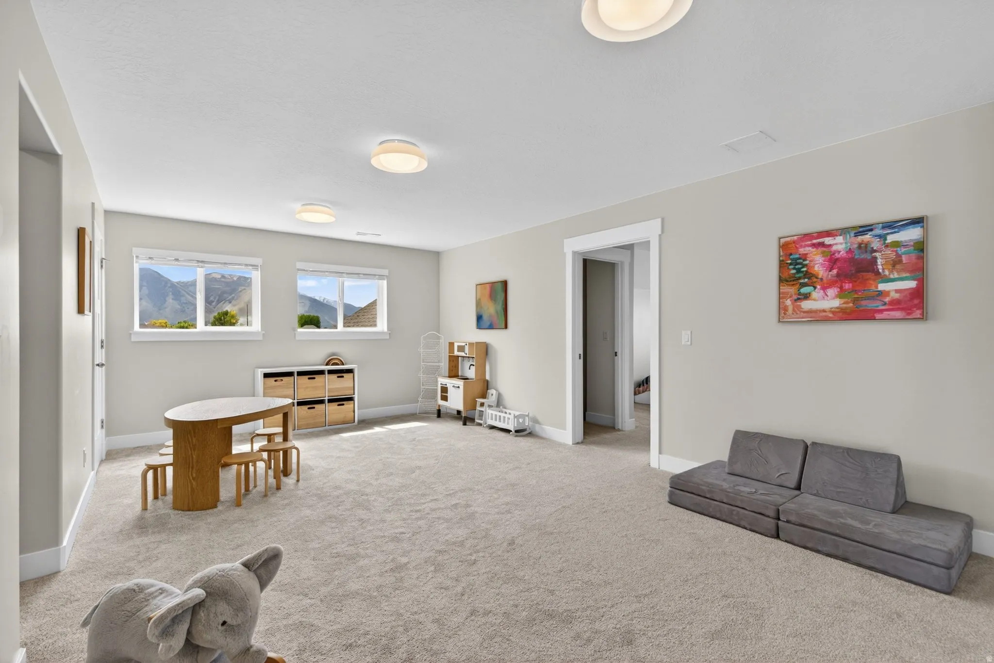Living area featuring light carpet and a mountain view